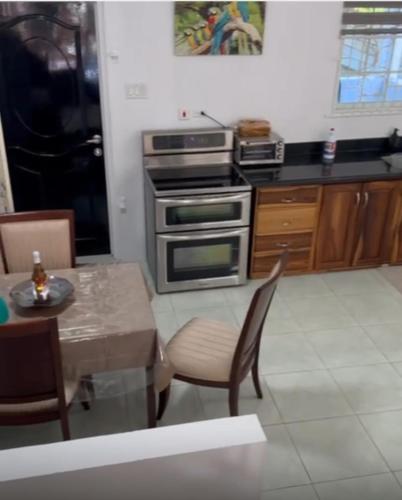 a kitchen with a stove and a table with chairs at Hidden Gem Emerald in Buff Bay Portland in Cascade