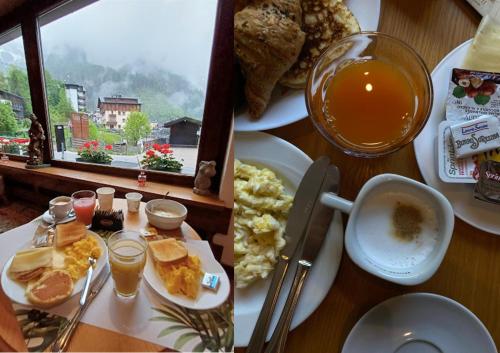 a table topped with plates of breakfast food and a window at Hotel TEA DOLOMITI - Lago di Alleghe - Monte Civetta in Alleghe