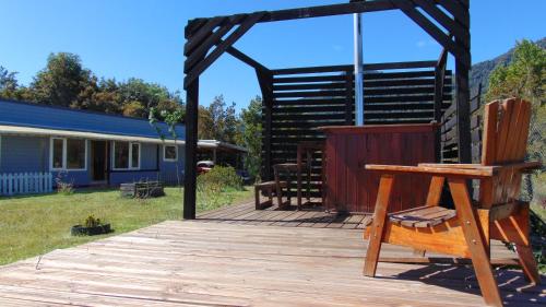 a wooden deck with a pergola and a house at Casa Quillaipe in Puerto Montt