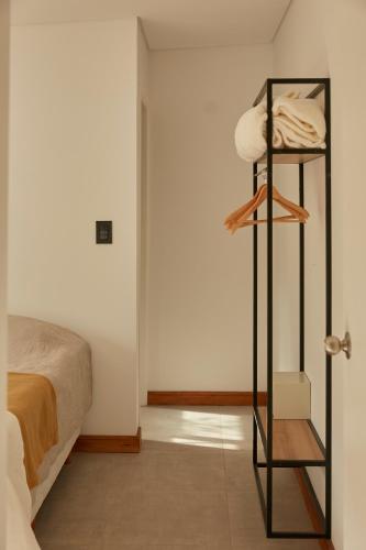 a room with a bed and a shelf with towels at Ayres Lodge Vista Calma Potrerillos in Potrerillos