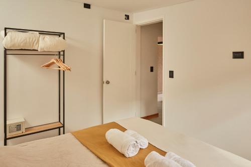 a bedroom with a bed with two towels on it at Ayres Lodge Vista Calma Potrerillos in Potrerillos