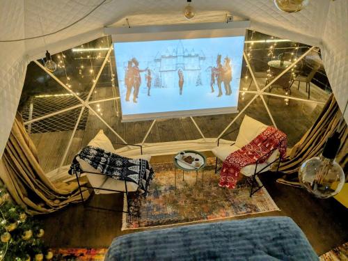 a living room with a projection screen and a bed at Glamping Daphenili in Tskalt'ashua