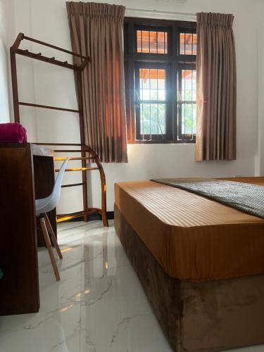 a bedroom with a bed and a chair and a window at Transit Terminal at colombo airport in Katunayake