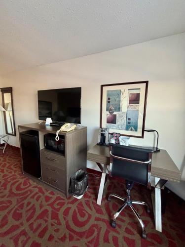 a hotel room with a desk and a chair at Ramada by Wyndham Sherwood Park in Sherwood Park