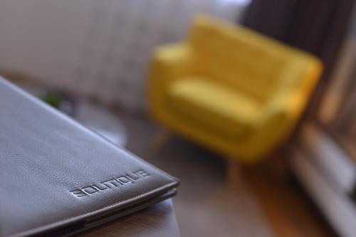 a close up of a leather wallet on a table with a yellow chair at Boutique Rooms in Belgrade