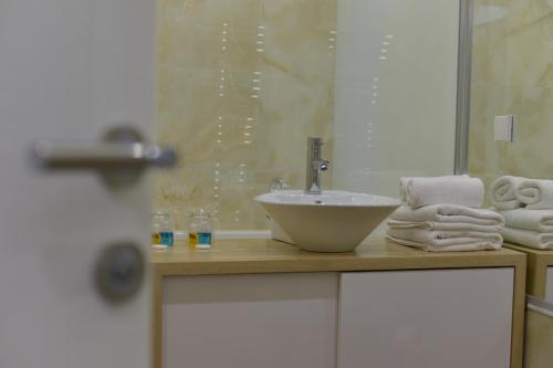 a bathroom with a sink and towels on a counter at Boutique Rooms in Belgrade