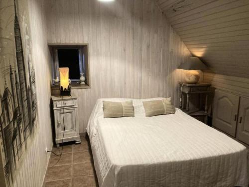 a bedroom with a white bed and a window at Gîte de France "les volets bleus" 3 épis - Gîte de France 12 personnes MAE-9484 in Espartignac