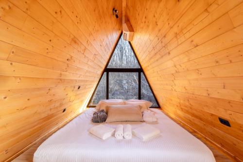 a bed in a wooden room with a large window at A villa in Marija Trošt