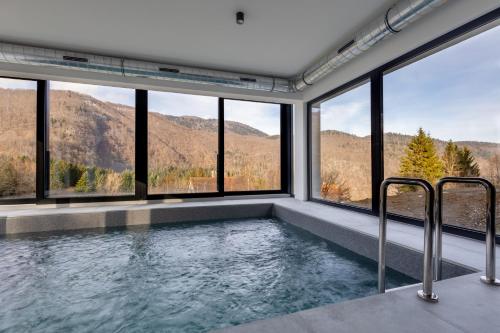 a jacuzzi tub in a room with windows at A villa in Marija Trošt