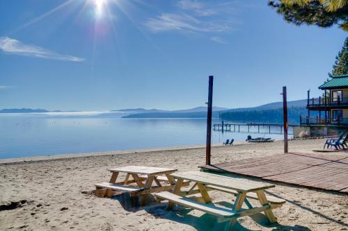 two picnic tables on a beach with a dock at Grill and Beach Access Cabin in Tahoe Vista! in Tahoe Vista