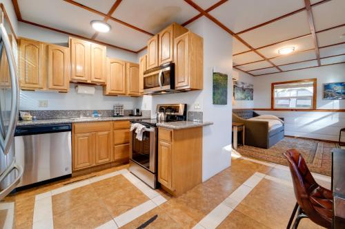 a kitchen with wooden cabinets and a living room at Grill and Beach Access Cabin in Tahoe Vista! in Tahoe Vista