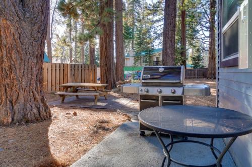 a grill and a picnic table next to a tree at Grill and Beach Access Cabin in Tahoe Vista! in Tahoe Vista