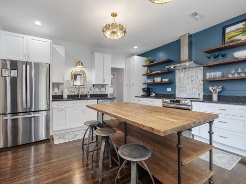 a kitchen with white cabinets and a wooden table at Brooklyn House, Downtown Wilmington in Wilmington