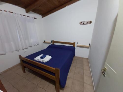 Habitación pequeña con cama azul y ventana en Casablanca, en La Adela