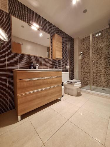 a bathroom with a sink and a toilet and a mirror at Ático Dúplex Baladrar Gran Terraza 8Km Playa Dénia-Oliva Nova Golf -IDEAL Familias y Grupos in Pego
