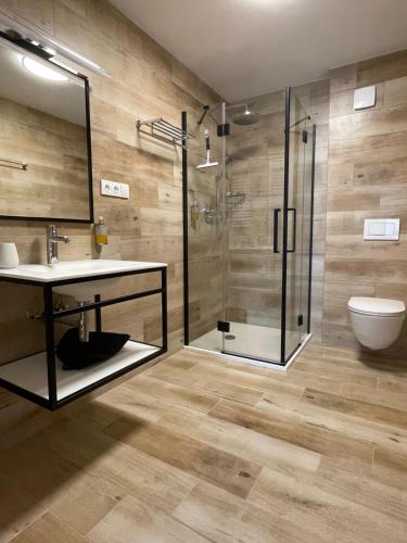 a bathroom with a shower and a sink and a toilet at Chata Smrčka in Železná Ruda