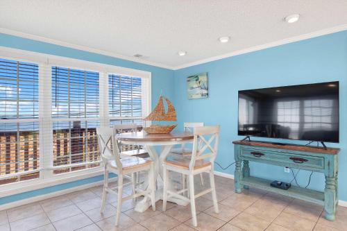 a dining room with a table and a television at Ocean front Rental 101-3 in Tybee Island