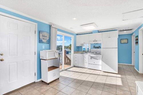 a kitchen with blue walls and white appliances at Ocean front Rental 101-3 in Tybee Island