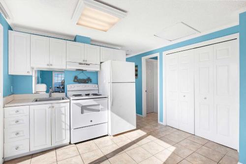 a kitchen with white appliances and blue walls at Ocean front Rental 101-3 in Tybee Island