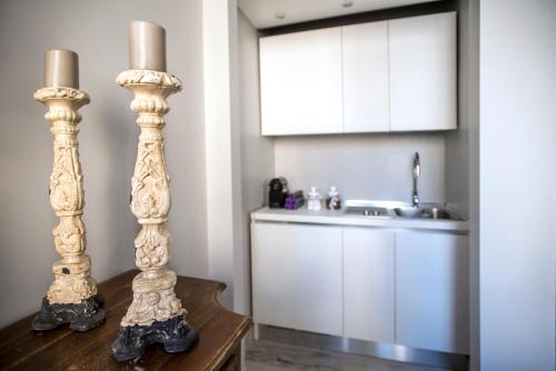 ローマにあるTrevi Luxury Maisonのシンクとテーブルの上に2本のキャンドルがあるキッチン