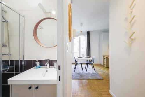 La salle de bains est pourvue d'un lavabo, d'un miroir et d'une table. dans l'établissement Cozy studio Le Nid Tranquille - All Equipped, à Grenoble