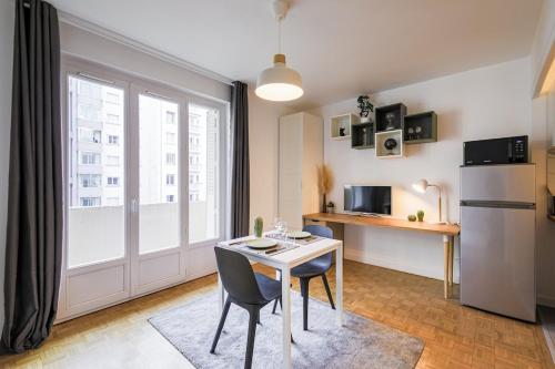 une petite cuisine avec une table et un réfrigérateur dans l'établissement Cozy studio Le Nid Tranquille - All Equipped, à Grenoble