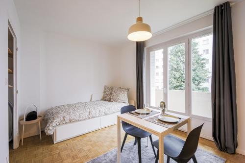 une chambre avec un lit, une table et des chaises dans l'établissement Cozy studio Le Nid Tranquille - All Equipped, à Grenoble