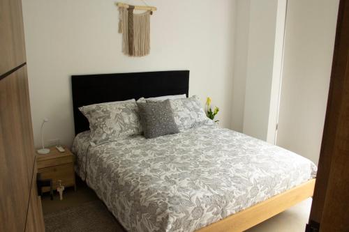 a bedroom with a bed and a wooden night stand at Norte Cali - Bosque Living -202 in Cali