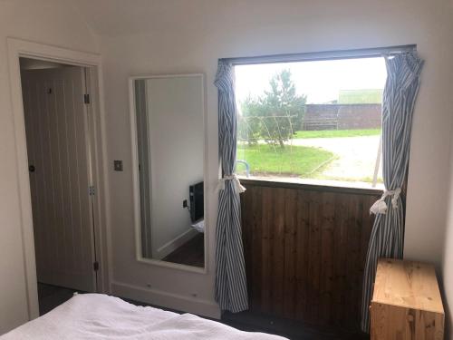 - une chambre avec une grande fenêtre et un miroir dans l'établissement The Nook, 1 Bedroom Cottage with Indoor Fireplace, à Poundon