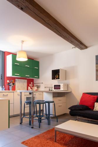 d'une cuisine et d'un salon avec des armoires vertes et une table. dans l'établissement Le Quai de Prague - Cosy - Central - Loire - Parking gratuit dans la rue, à Orléans