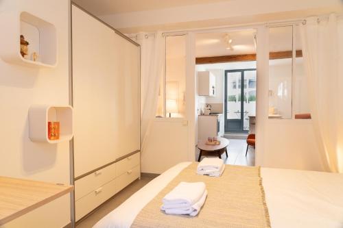 Cet appartement comprend une chambre avec deux lits et une porte menant à une cuisine. dans l'établissement Le Quai de Prague - Cosy - Central - Loire - Parking gratuit dans la rue, à Orléans