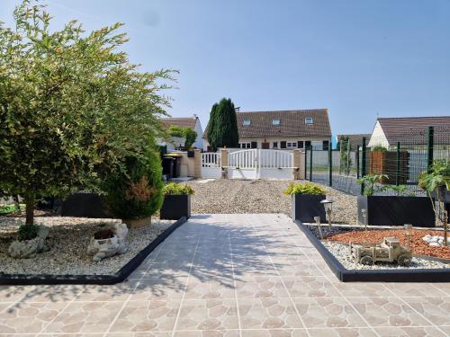 a garden with a walkway and trees and a fence at Maison calme avec jardin, vue champs et bois in Cambronne-lès-Clermont