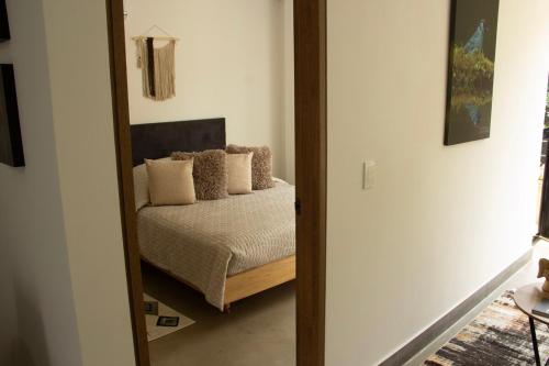 a mirror in a room with a bed with pillows at Norte Cali - Bosque Living -203 in Cali