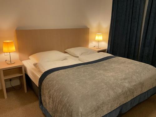 a bedroom with a large bed with two lamps on tables at Appartementen de Strandloper in Bergen aan Zee