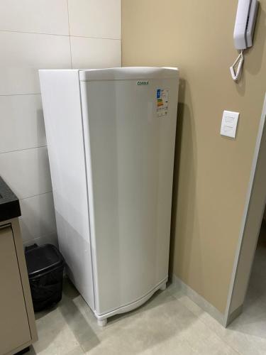 a white refrigerator in a kitchen next to a wall at Apartamento Palmeira in Formosa
