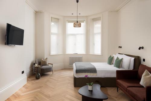 a white bedroom with a bed and a couch at FiveM West Hampstead - North in London