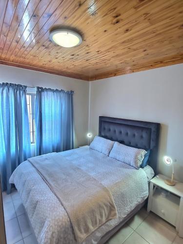 a bedroom with a bed and a wooden ceiling at Sea-Esta in Hentiesbaai