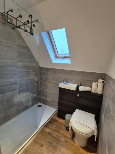 a bathroom with a toilet and a tub and a window at Rosies Retreat 2 Bedroom Farm Cottage in Preston Bisset