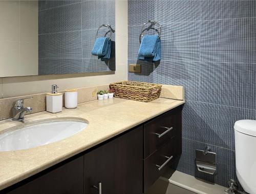 a bathroom with a sink and a mirror and a toilet at Depto Boulevard del Sol II in Viña del Mar