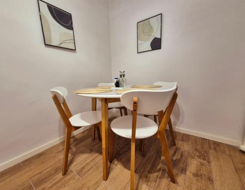 una mesa y sillas en una habitación con pinturas en Botev Inn - R2, en Sofía