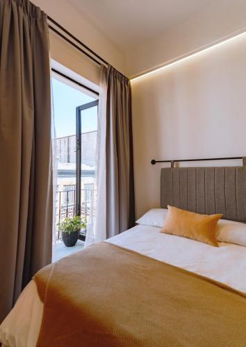 a bedroom with a bed and a large window at Departamento recién remodelado en centro histórico in Puebla
