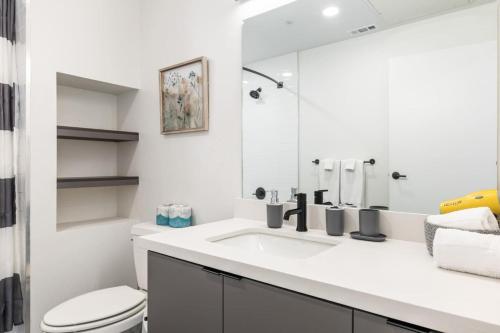 a white bathroom with a sink and a toilet at 2BD Modern DTLA Apartment Minutes from Dodger Stadium in Los Angeles