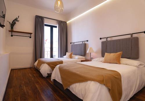ein Hotelzimmer mit zwei Betten und einem Fenster in der Unterkunft Departamento recién remodelado en centro histórico in Puebla