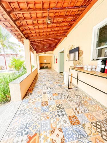 a hallway with a tile floor with a ceiling at Caju Villa Hostel in Aracaju