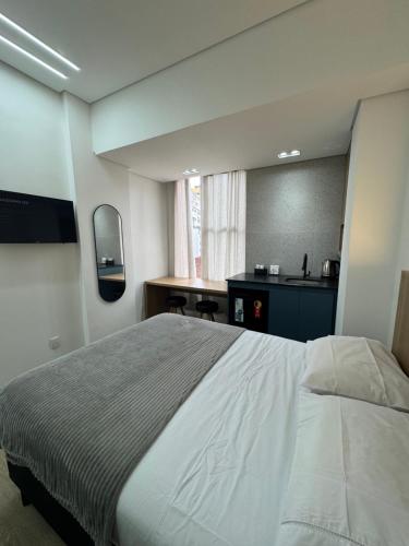 a bedroom with a large bed and a bathroom at Studio no centro, confortável e prático in Florianópolis