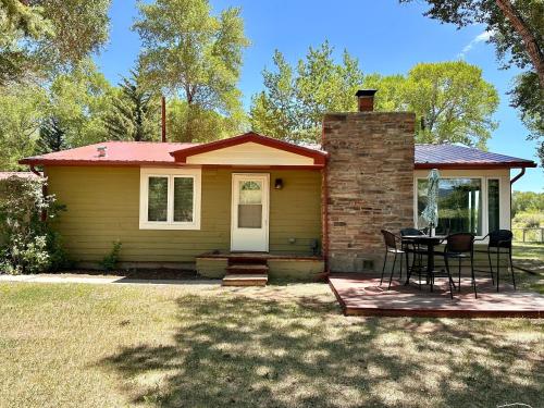 a small house with a table and chairs on a deck at Chinook Winds Lodge in Dubois