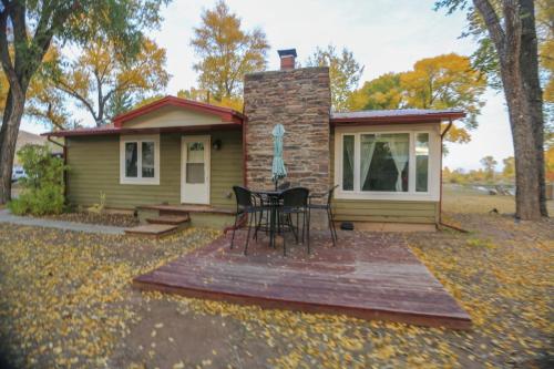 a small house with a table and chairs on a deck at Chinook Winds Lodge in Dubois