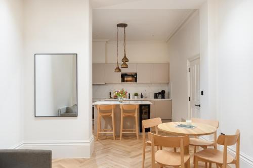 a kitchen and dining room with a table and chairs at FiveM West Hampstead - North in London
