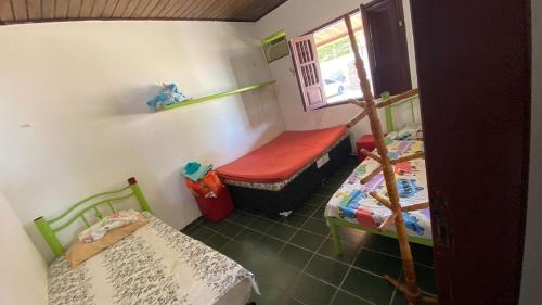 una piccola stanza con due letti e una finestra di Casa barra Grande a Maragogi