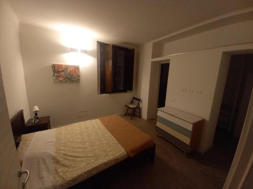 a bedroom with a bed and a chair and a window at Console Camprini Estates - Faenza Apartments 2 in Faenza